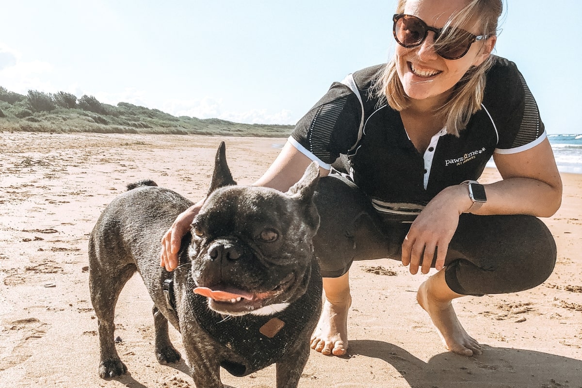 Dog Walker at the beach with dog practicing sun safety for dogs