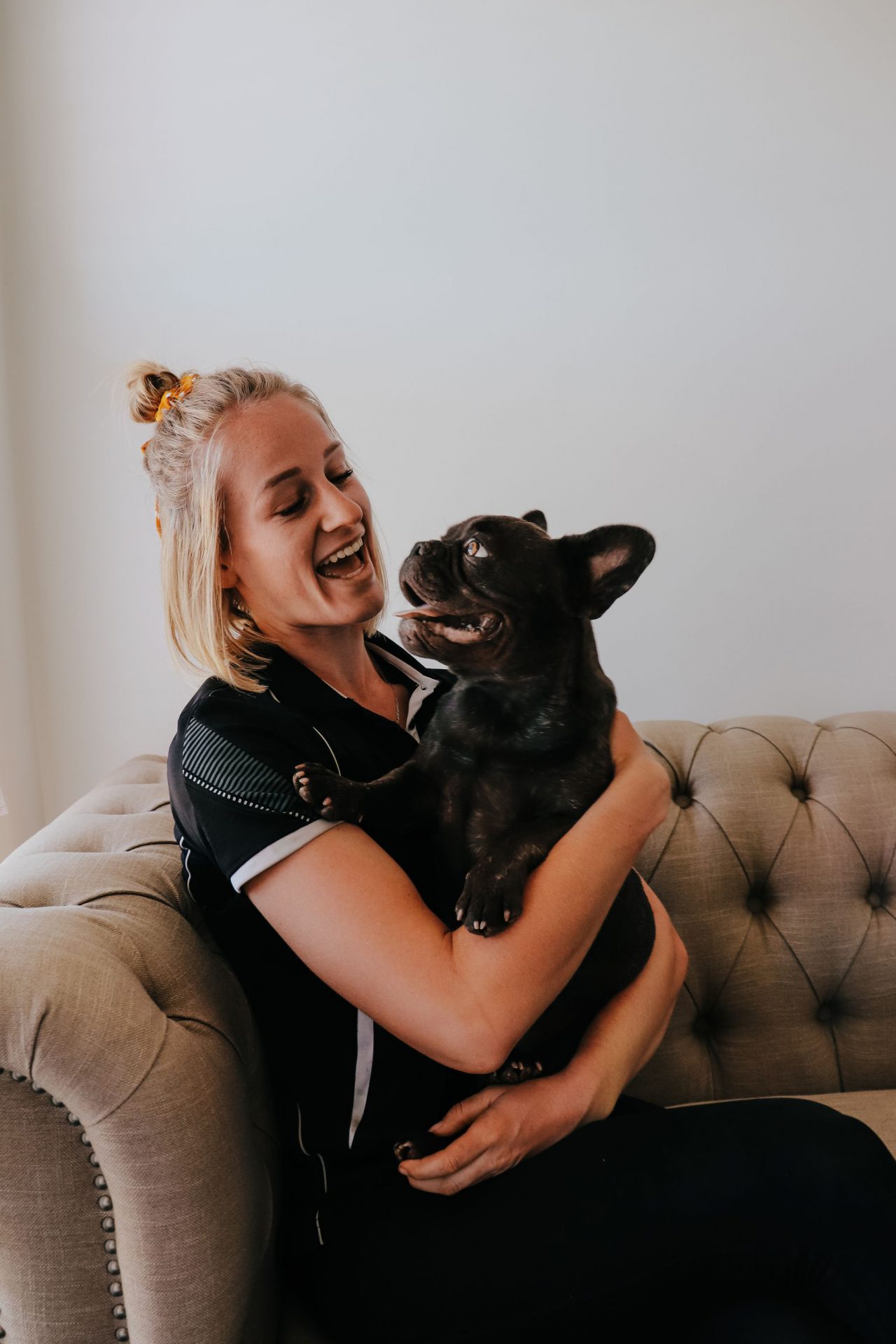 A woman holds a French Bulldog puppy